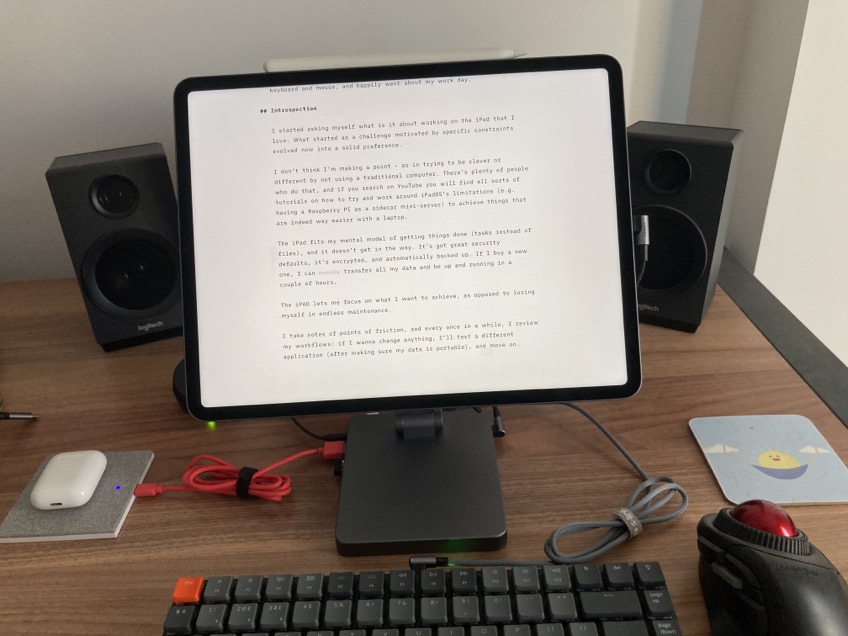 Photo of my desk showing the iPad with its stand, keyboard, and trackball